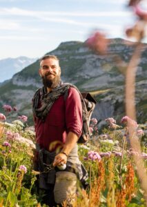 Portrait of man with Viking look hiking near Leysin, Switzerland, surrounded by tall wildflowers