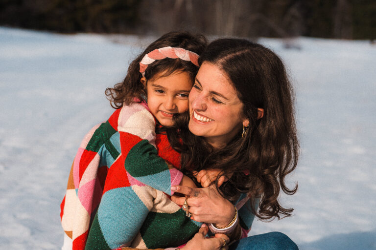 Mother and young daughter cuddling during a winter family portrait session - captured by Maaike Jansen Photography