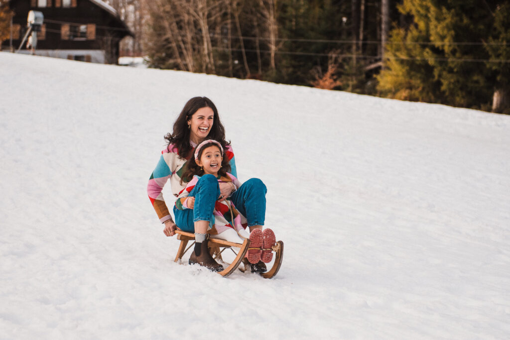 Mother and daugther having fun on a sled in a snowy landscape nearby Montreux - captured by Maaike Jansen Photography
