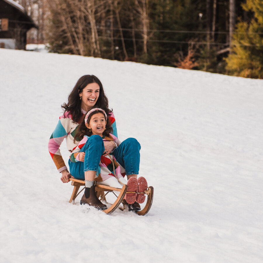 Mother and daugther having fun on a sled in a snowy landscape nearby Montreux - captured by Maaike Jansen Photography
