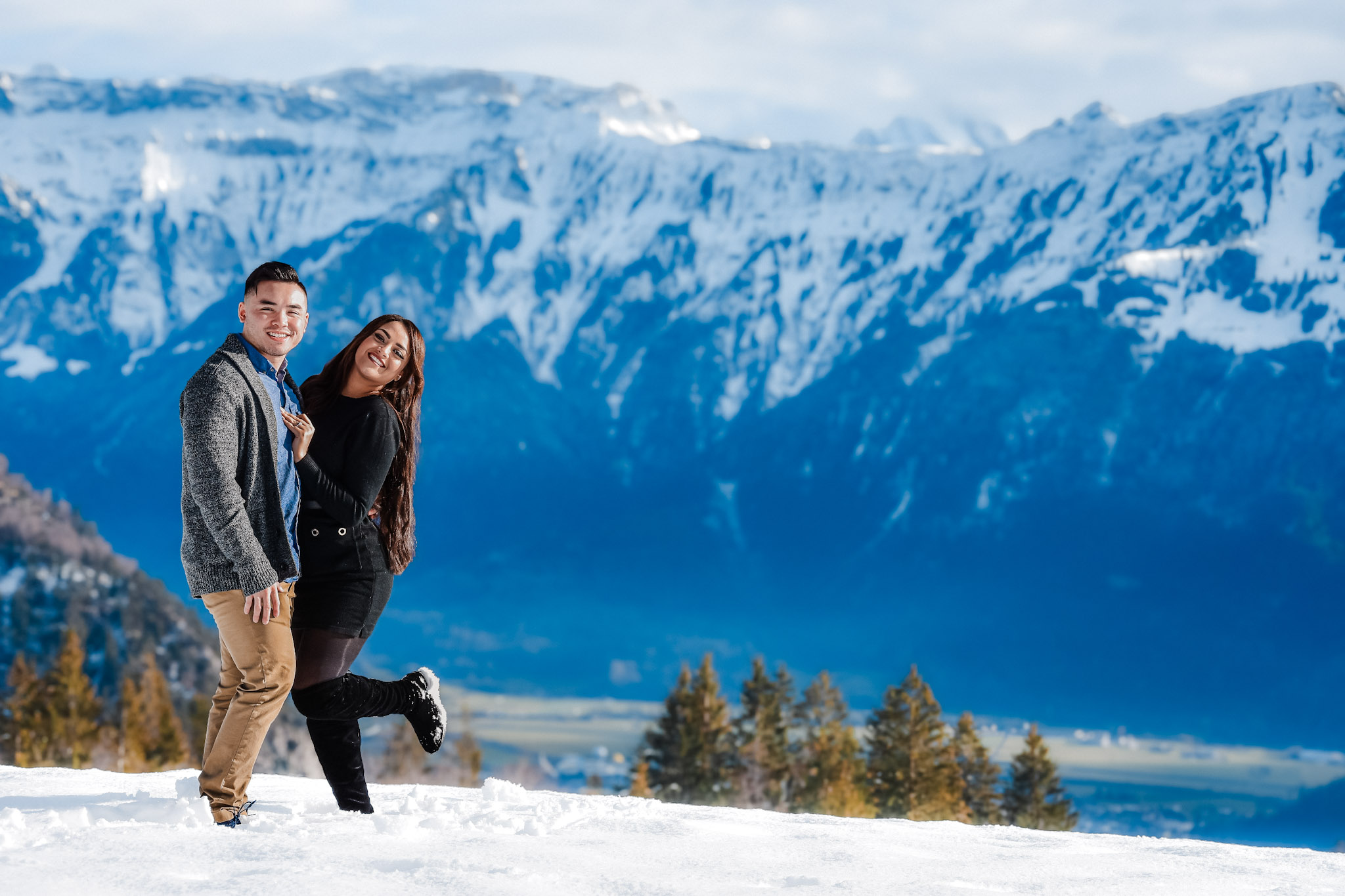 Couple embracing during a natural outdoor photo session in Switzerland, relaxed and candid moment