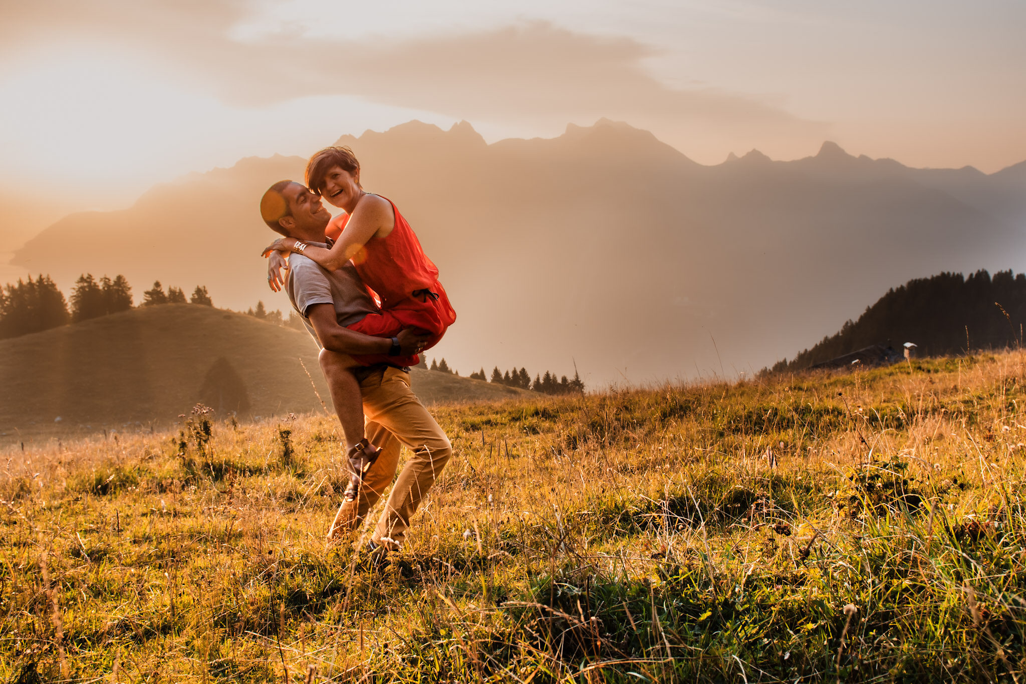 Romantic couple hugging eachother in nature in Switzerland during golden hour photo session