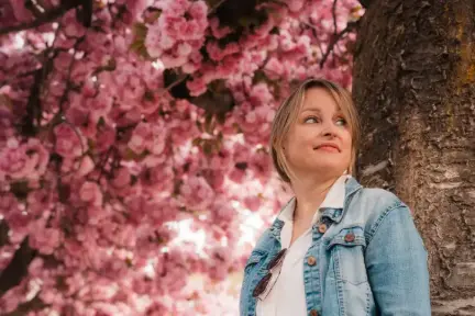 Woman smiling under an apple tree in full blossom in switzerland during a photo session