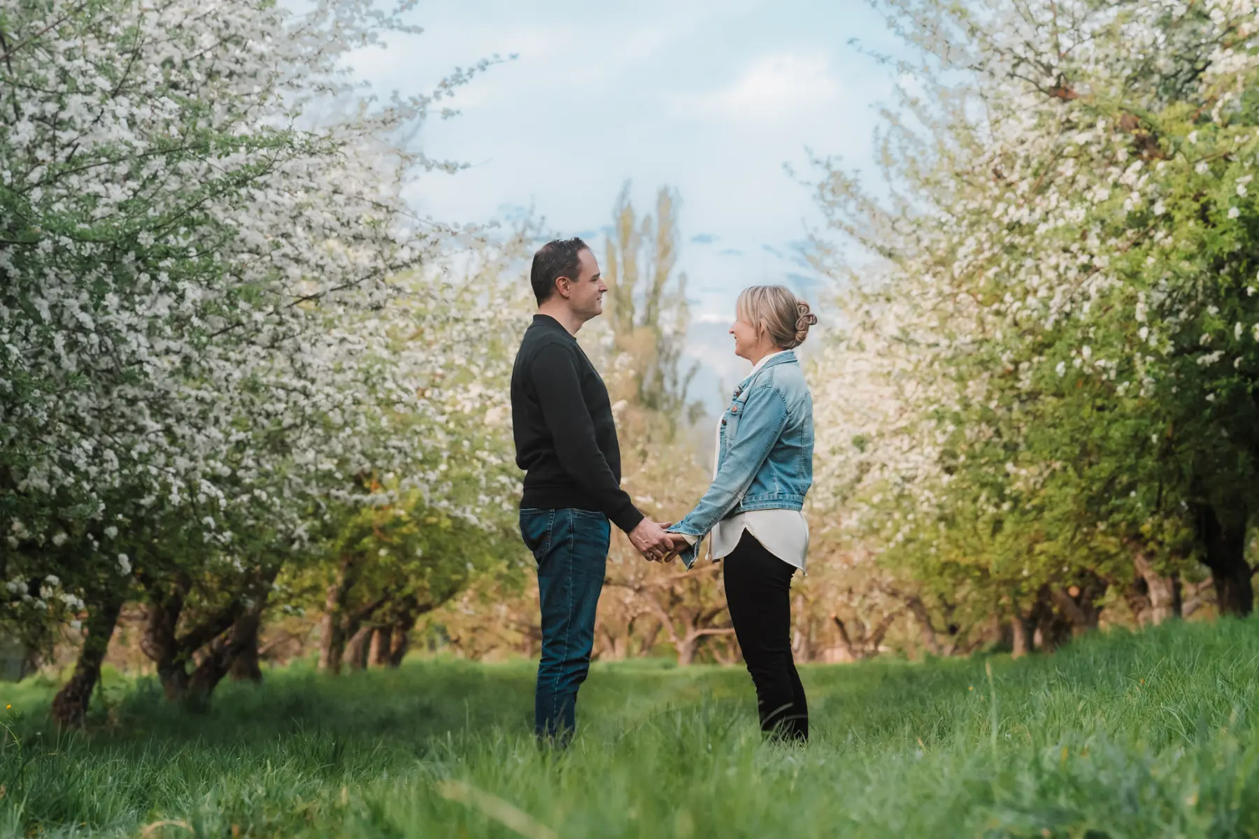 couple looking at eachother in an apple orchard in switzerland