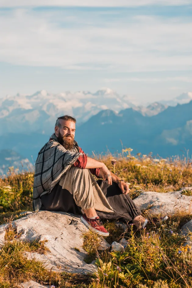 Man sitting on a rock in a beautiful Swiss alps scenery during an adventure photo session in Switzerland
