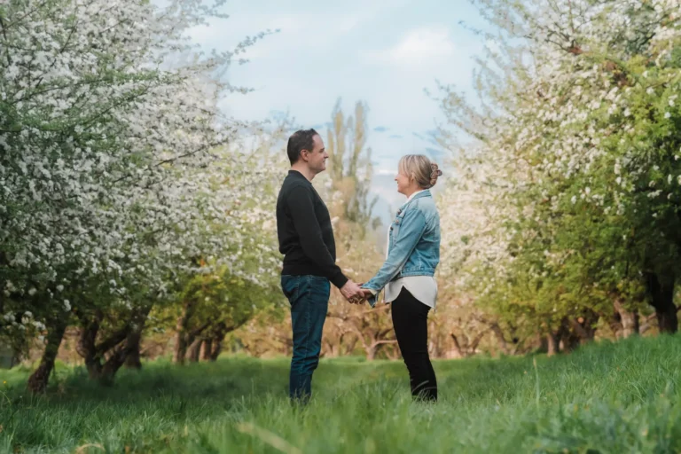 couple standing in a blooming apple orchards in switzerland