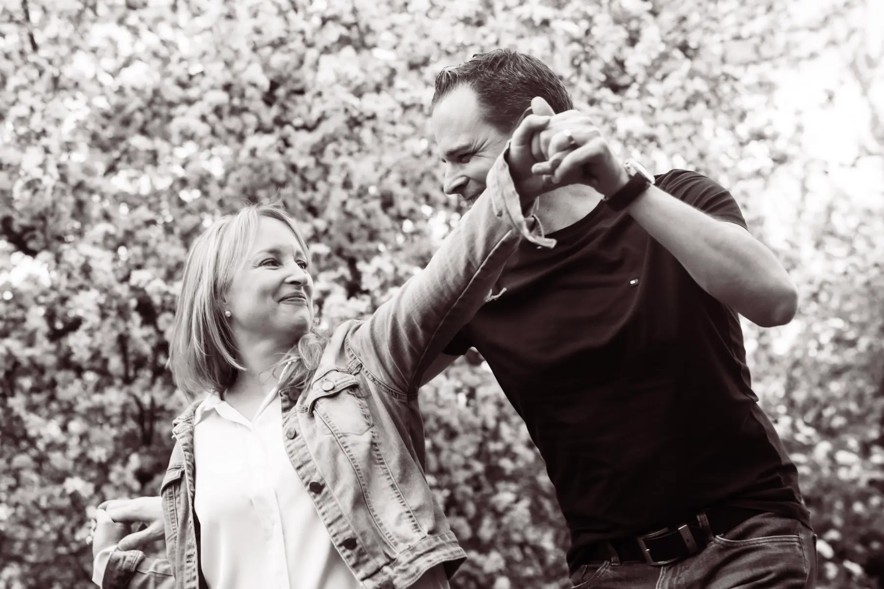 Couple celebrating their 22nd wedding anniversary in blooming apple orchards surrounded by mountain views in Switzerland.