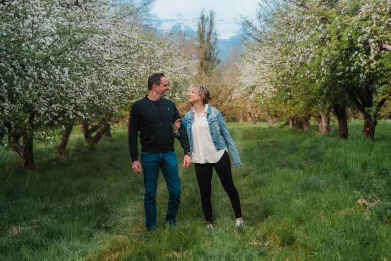 couple goofing together during a spring photo session in Swiss apple orchards
