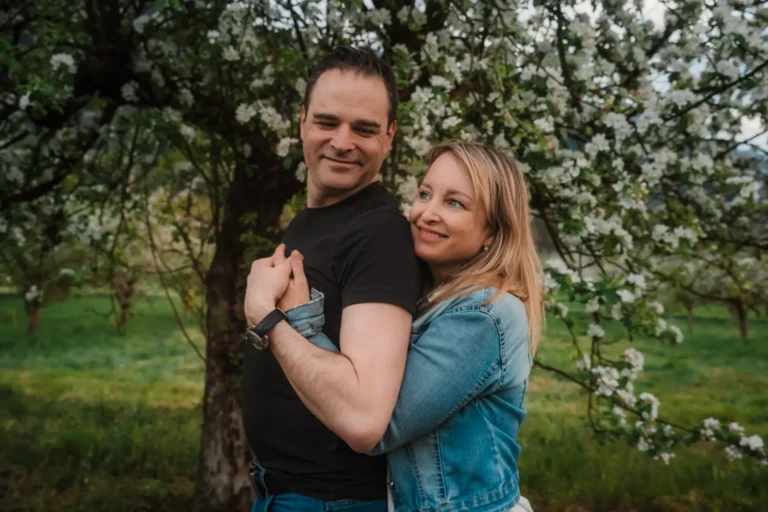 wife smiling while hugging her husband during an outdoors portrait experience
