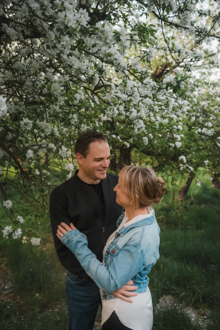 couple hugging under apple trees