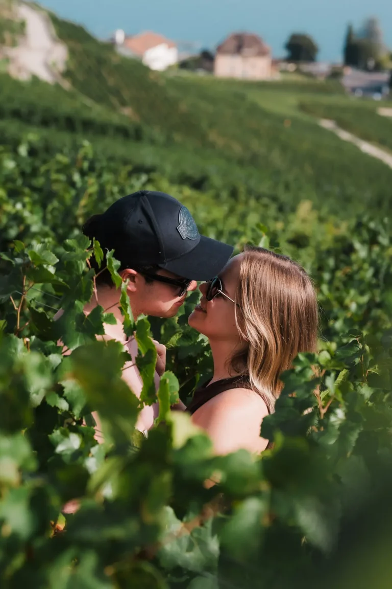Romantic portrait of Dimitris and Alisa surrounded by green grapevines in Lavaux.